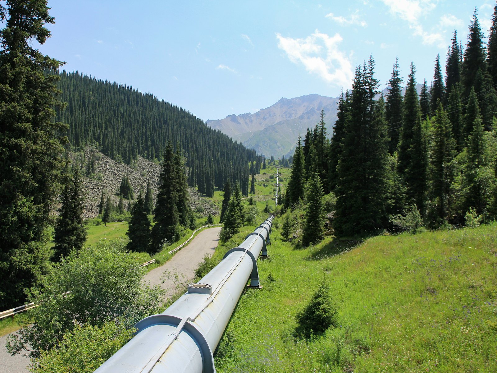 A pipeline running through a green mountain valley