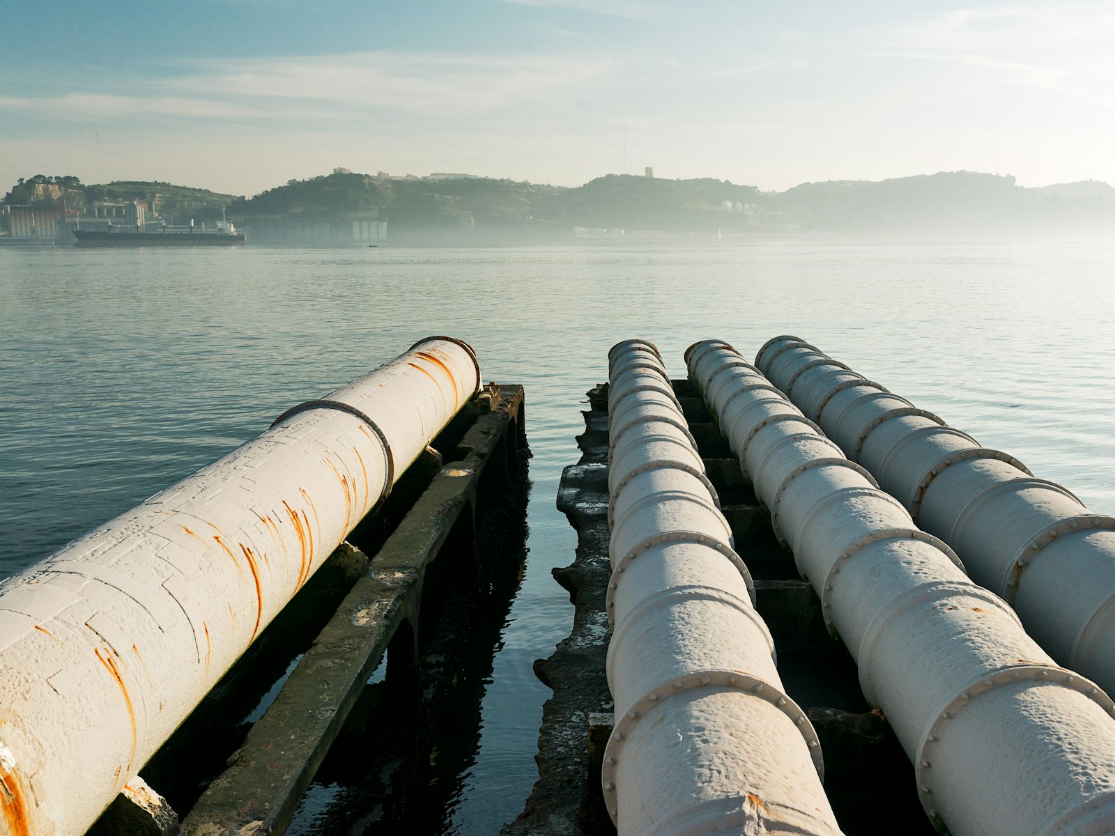 Parallel pipelines running out over the water to a shoreline